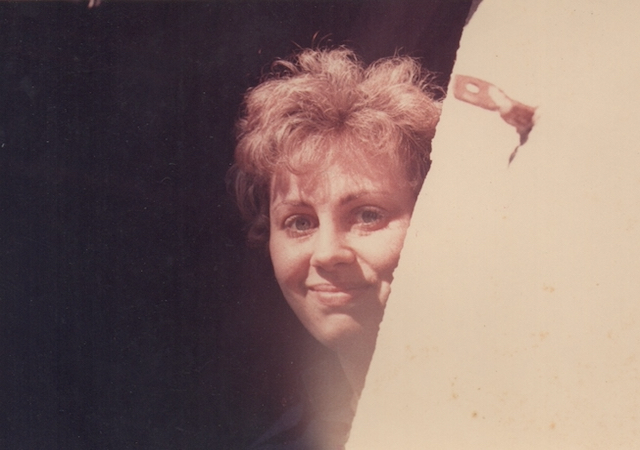 Red haired woman, smiling with blue eyes.